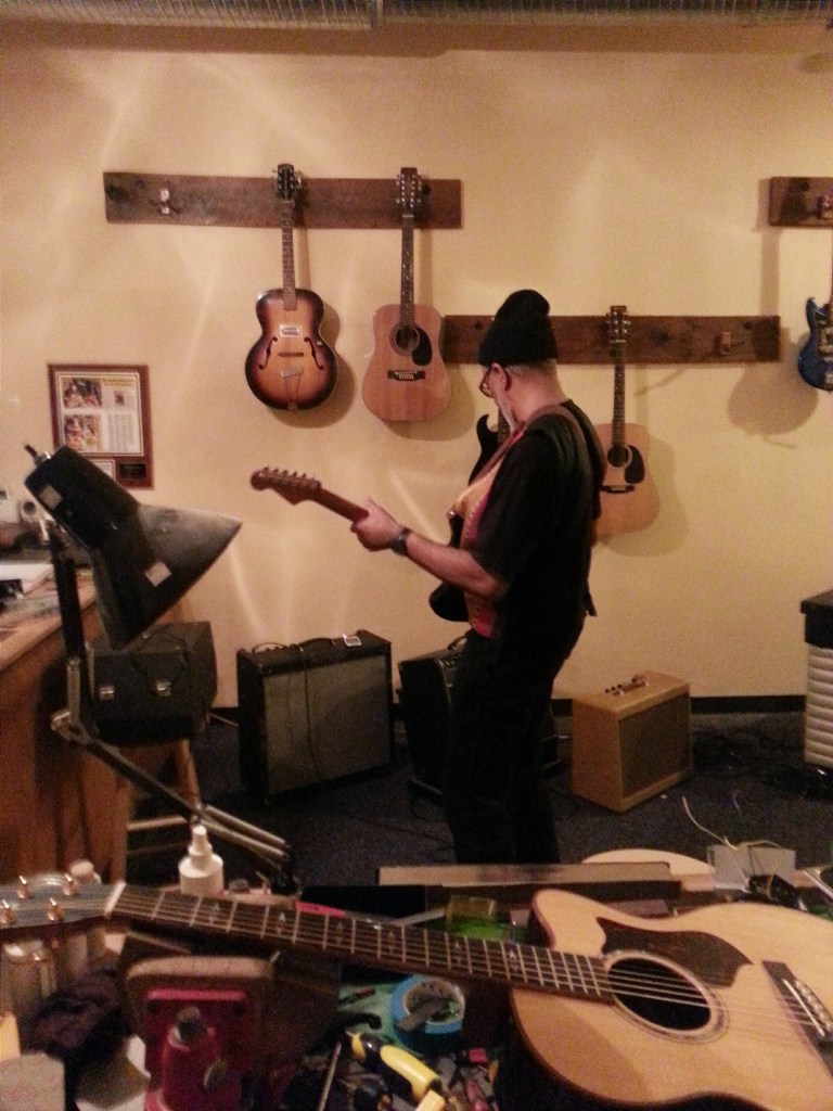 Lorenzo "Logie" Meachum tries out some of Brian's guitars after the Sardine Session at Pinebox studios in Graham.